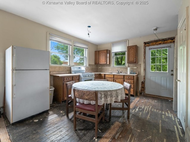 kitchen with backsplash, dark hardwood / wood-style flooring, plenty of natural light, and white appliances