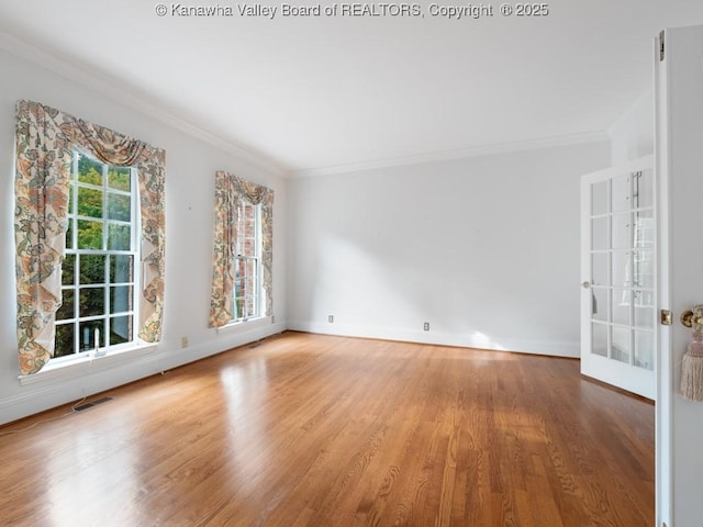 empty room with french doors, wood-type flooring, and ornamental molding