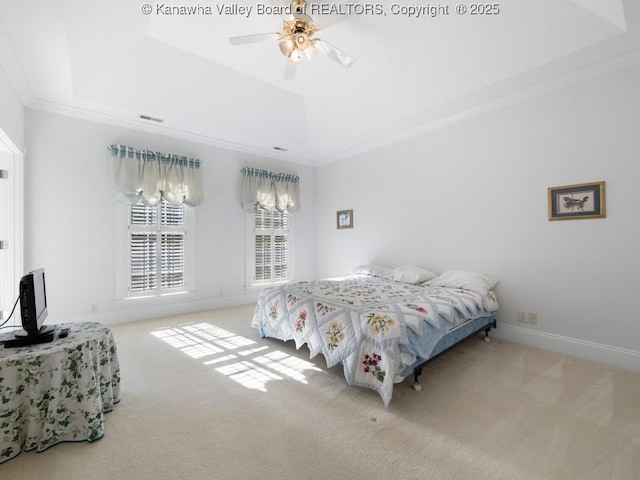 carpeted bedroom featuring a tray ceiling, ceiling fan, and ornamental molding