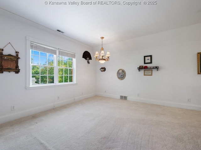 spare room with light colored carpet and a chandelier