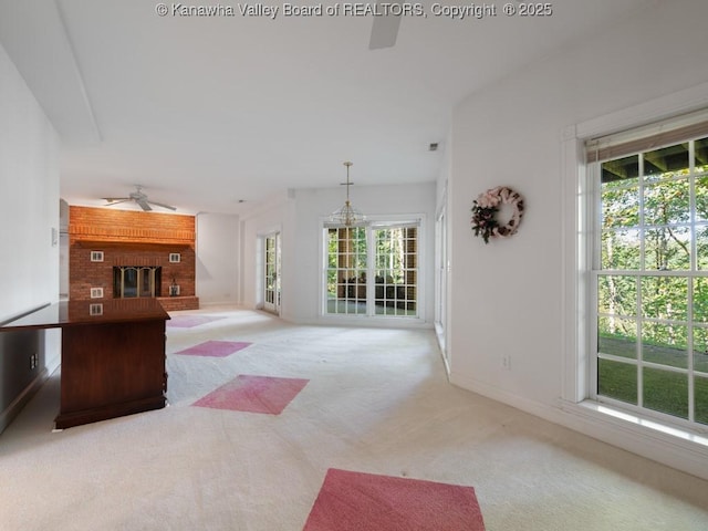 carpeted living room featuring ceiling fan, plenty of natural light, and a brick fireplace