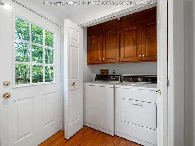 clothes washing area featuring cabinets, light hardwood / wood-style flooring, washer and clothes dryer, and ornamental molding