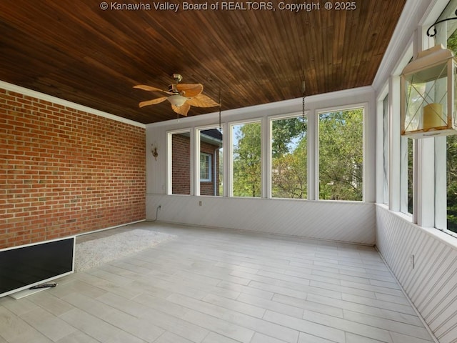 unfurnished sunroom featuring a wealth of natural light, ceiling fan, and wood ceiling