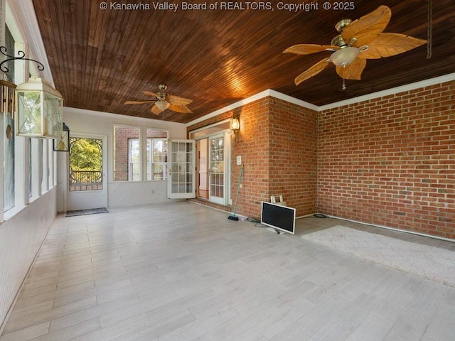 unfurnished sunroom featuring ceiling fan and wood ceiling