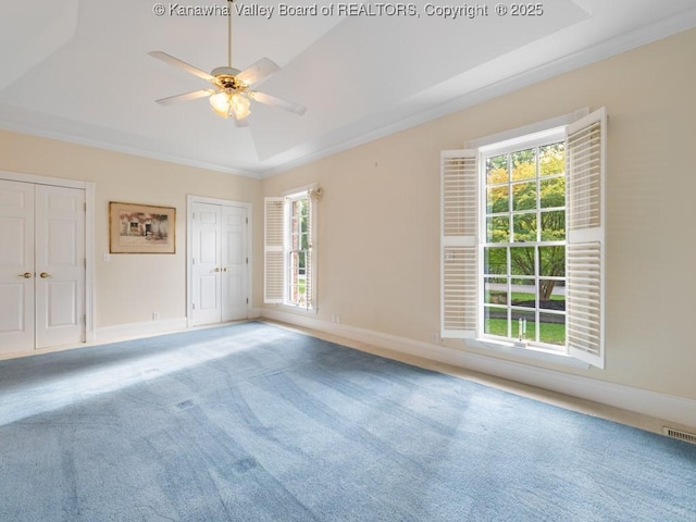 unfurnished room featuring carpet floors, a tray ceiling, ceiling fan, and ornamental molding