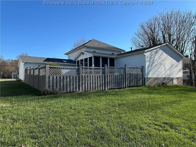 back of house featuring a yard and a sunroom