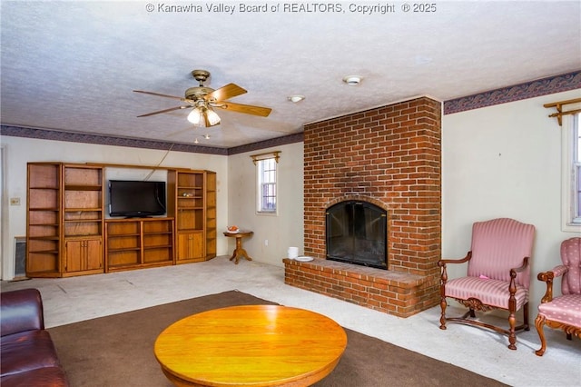 carpeted living room with ceiling fan, a fireplace, and a textured ceiling