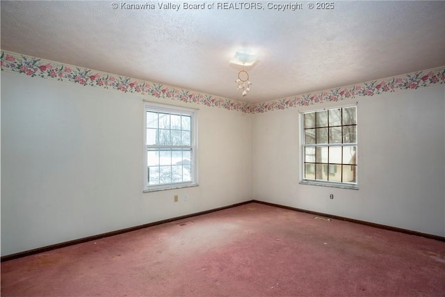 carpeted spare room featuring a textured ceiling