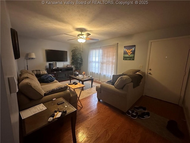 living room with hardwood / wood-style floors, ceiling fan, and a textured ceiling