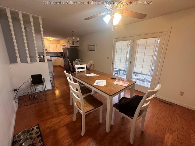 dining space with ceiling fan with notable chandelier and dark hardwood / wood-style flooring