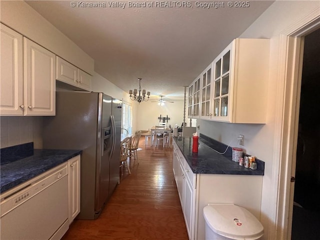 kitchen featuring dark hardwood / wood-style floors, backsplash, white dishwasher, decorative light fixtures, and white cabinets