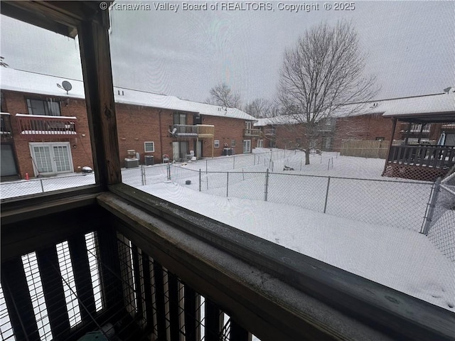 view of snow covered back of property