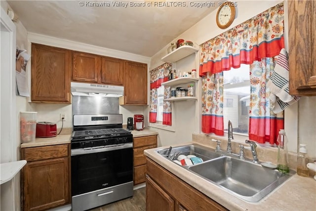 kitchen featuring gas stove, dark hardwood / wood-style flooring, ornamental molding, and sink