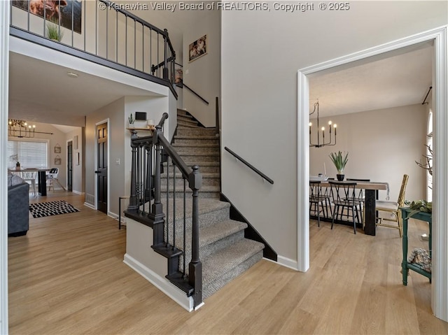 stairway featuring hardwood / wood-style floors and a notable chandelier