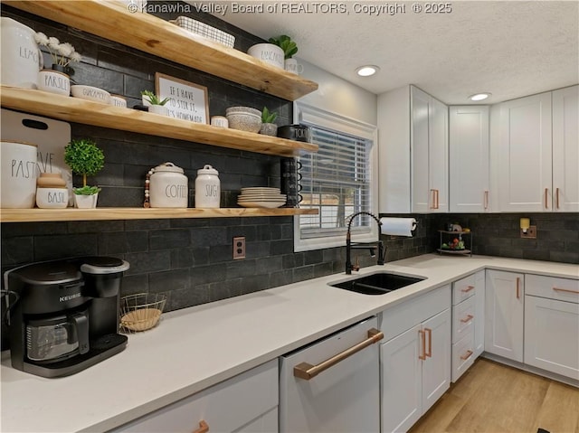 kitchen featuring white cabinets, dishwasher, and sink