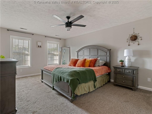 carpeted bedroom with ceiling fan and a textured ceiling