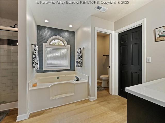 bathroom with hardwood / wood-style floors, separate shower and tub, and toilet