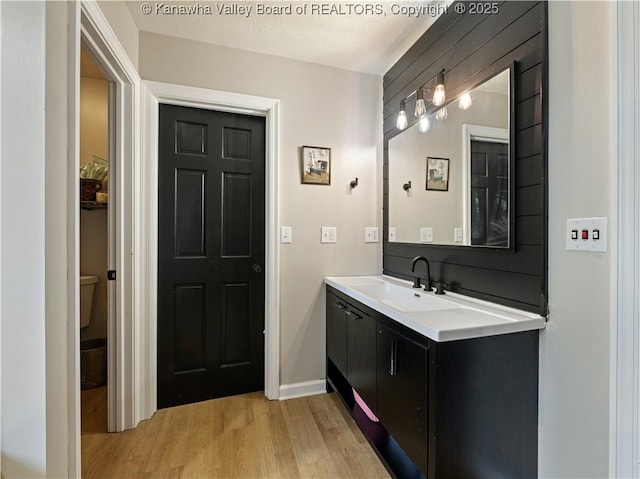 bathroom featuring hardwood / wood-style floors, vanity, and a textured ceiling