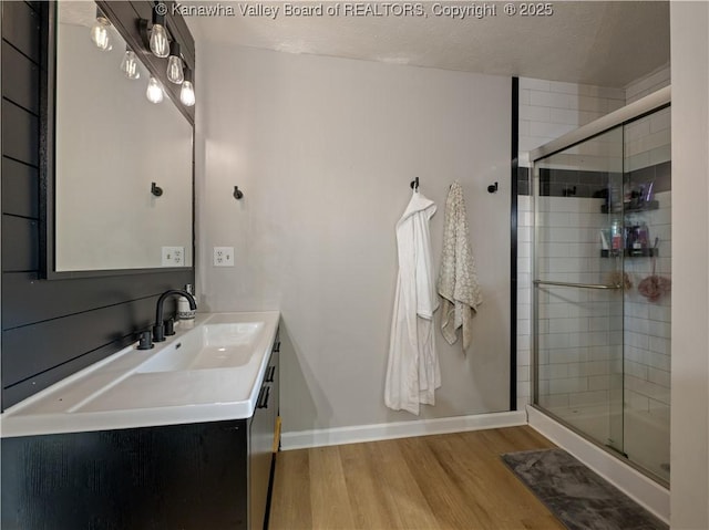 bathroom featuring hardwood / wood-style floors, vanity, an enclosed shower, and a textured ceiling