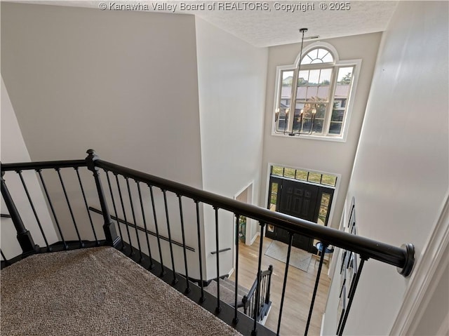 stairway featuring a textured ceiling