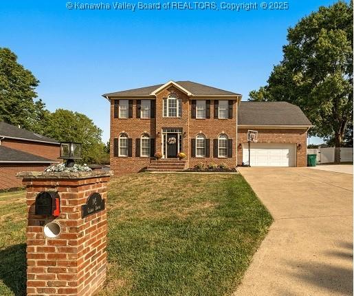 colonial home featuring a garage and a front yard