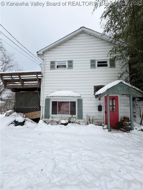 view of snow covered back of property