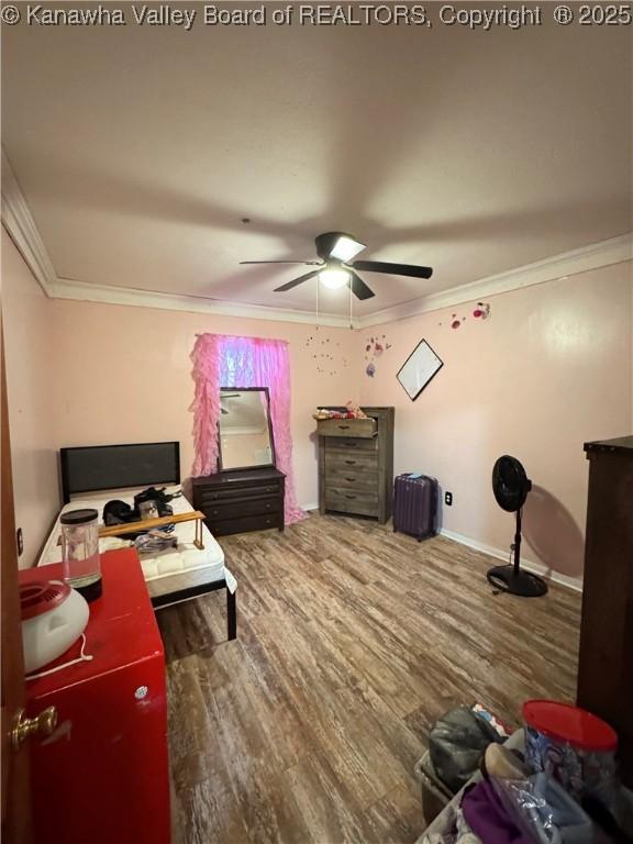 bedroom featuring ceiling fan, crown molding, and hardwood / wood-style flooring