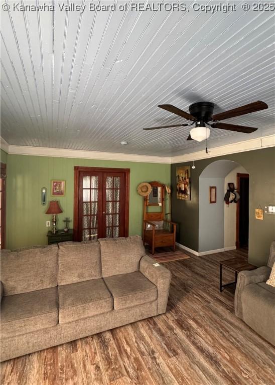 living room with ceiling fan, crown molding, wood-type flooring, and wooden ceiling