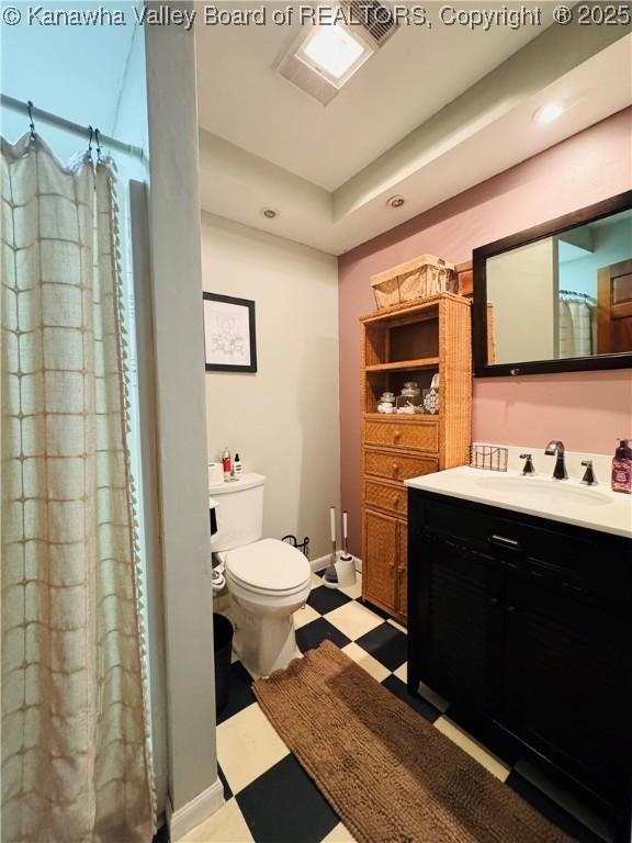 bathroom with toilet, walk in shower, and vanity