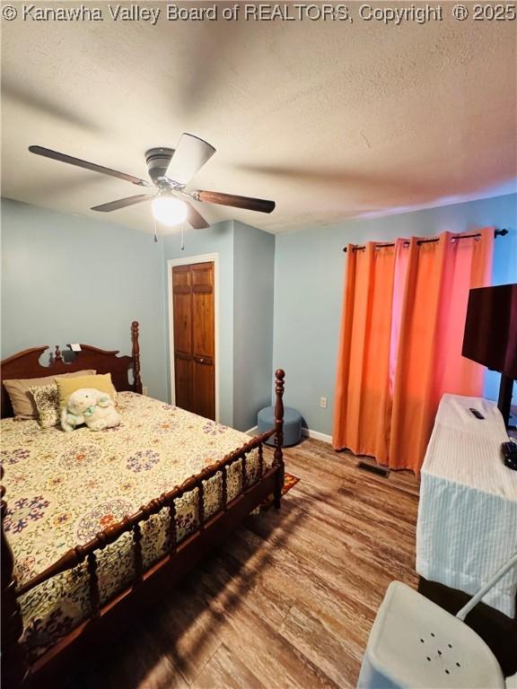 bedroom featuring ceiling fan, a closet, and wood-type flooring