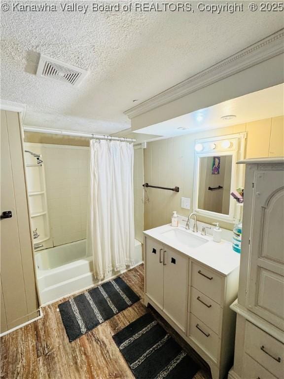 bathroom featuring vanity, hardwood / wood-style floors, crown molding, a textured ceiling, and shower / tub combo with curtain