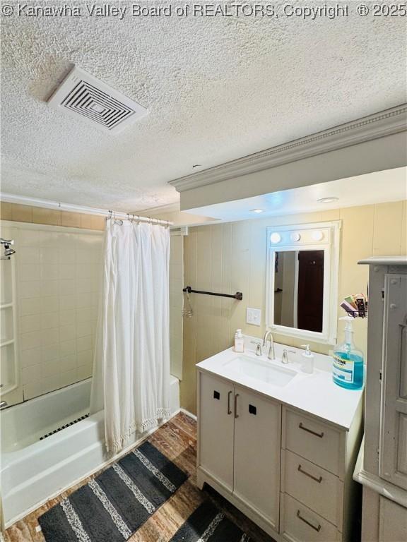 bathroom featuring hardwood / wood-style flooring, shower / bath combo, a textured ceiling, crown molding, and vanity