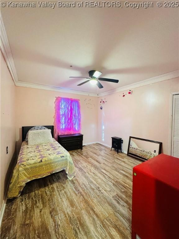 bedroom featuring ceiling fan, wood-type flooring, and ornamental molding