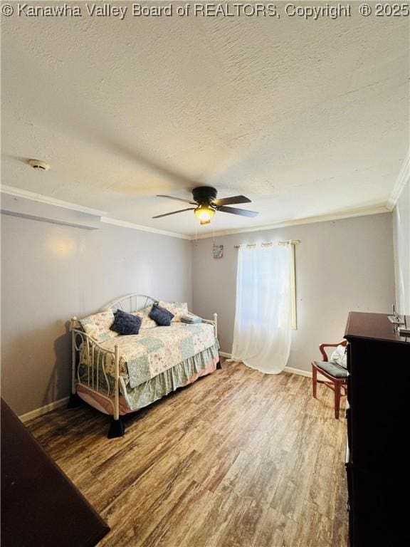 bedroom featuring a textured ceiling, ceiling fan, ornamental molding, and wood-type flooring