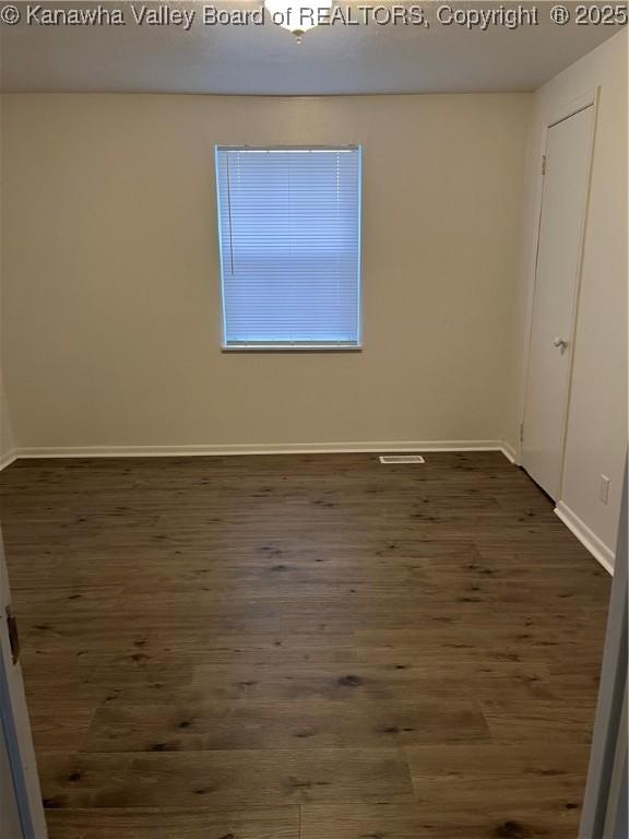 spare room with dark hardwood / wood-style flooring