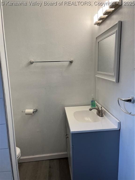 bathroom featuring hardwood / wood-style floors, vanity, and toilet