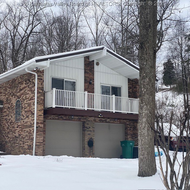 view of front of property featuring a balcony and a garage