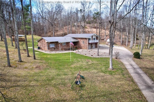 view of front of property with aphalt driveway, a front yard, brick siding, and an attached garage