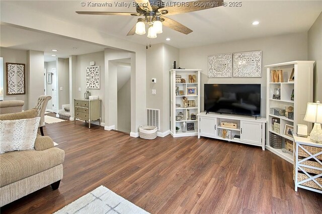 living room with dark hardwood / wood-style floors and ceiling fan