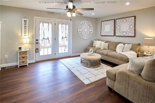 living room featuring dark wood-type flooring and ceiling fan