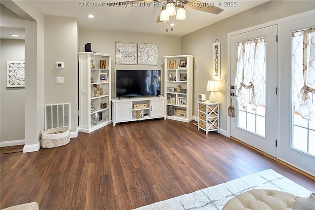 unfurnished living room with ceiling fan, plenty of natural light, and dark hardwood / wood-style floors