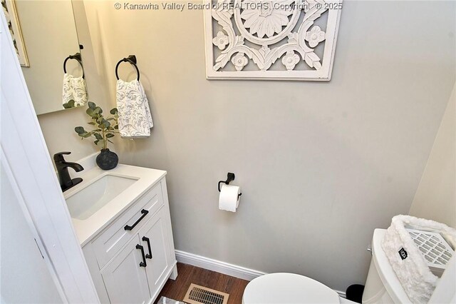 bathroom with vanity, hardwood / wood-style floors, and toilet