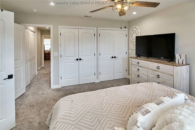 bedroom featuring multiple closets, carpet floors, and ceiling fan