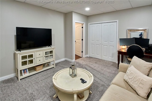 carpeted living room with a paneled ceiling