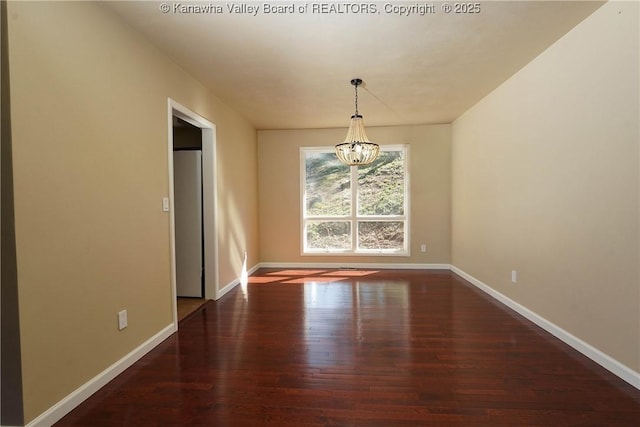 unfurnished dining area featuring dark wood-type flooring and a notable chandelier