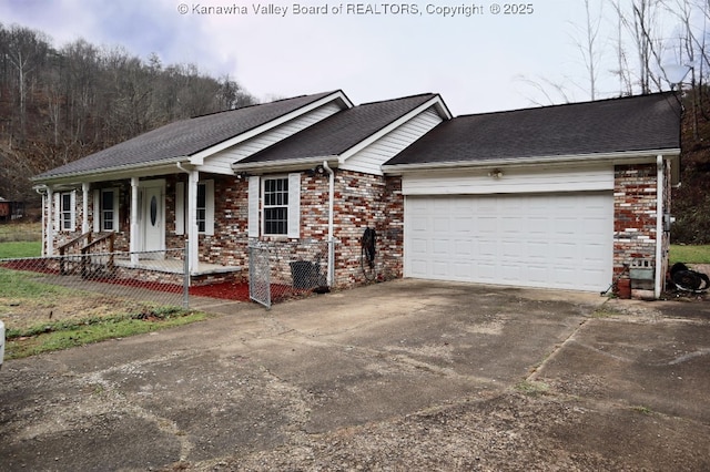 ranch-style home featuring covered porch and a garage