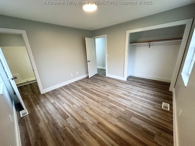 unfurnished bedroom with a closet and wood-type flooring