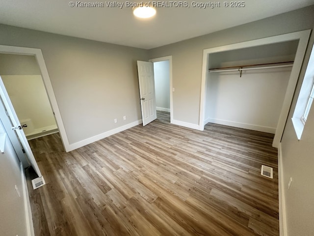 unfurnished bedroom with a closet and hardwood / wood-style flooring