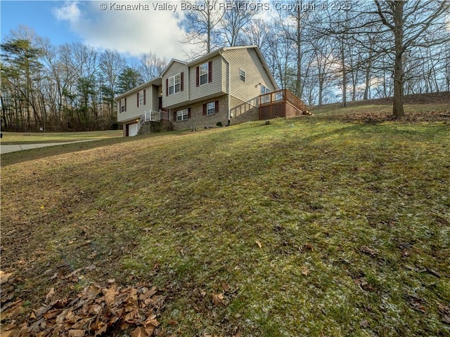 view of side of property featuring a deck, a yard, and a garage