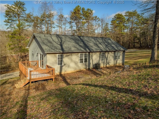 back of house featuring a deck, a yard, and central AC